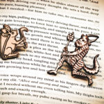A set of two pins, one featuring a rabbit with a shield on its back holding an axe, the other featuring a medieval satyr holding a branch, laser engraved on raw birch on top of the page of a book.