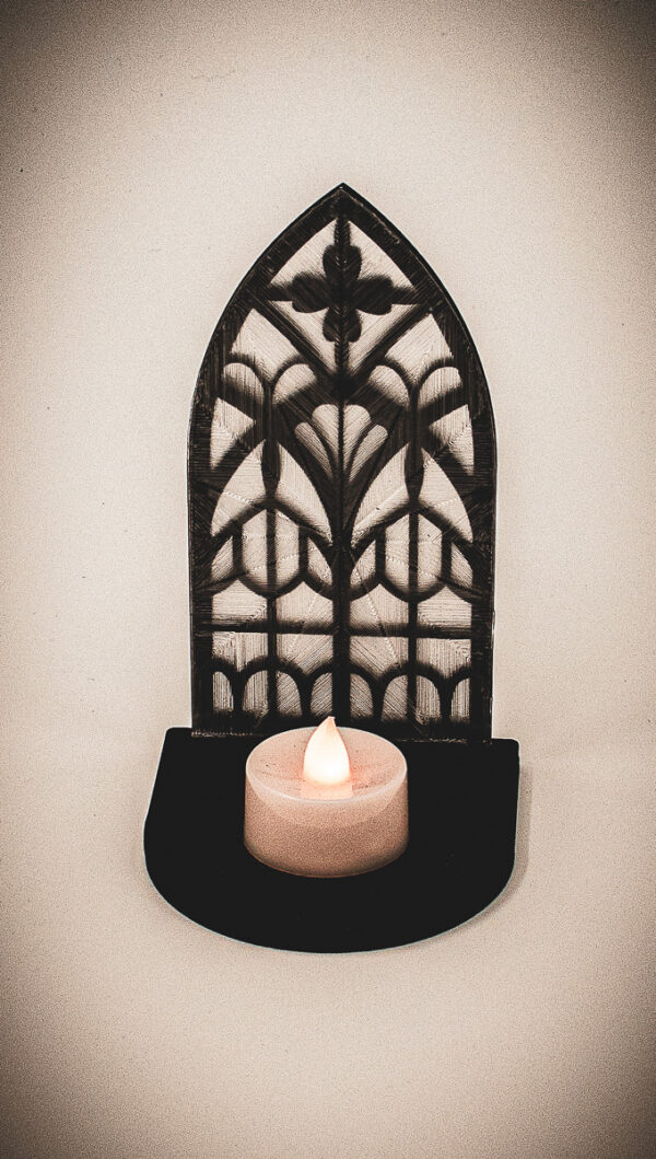 The back of an architectural book nook lantern featuring laser-cut Gothic cathedral window tracery made from 1/8 inch birch plywood painted matte black.
