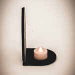 The side of an architectural book nook lantern featuring laser-cut Gothic cathedral window tracery made from 1/8 inch birch plywood painted matte black.