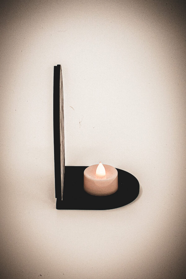 The side of an architectural book nook lantern featuring laser-cut Gothic cathedral window tracery made from 1/8 inch birch plywood painted matte black.