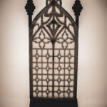 The back of an architectural book nook lantern featuring laser-cut Gothic cathedral window tracery made from 1/8 inch birch plywood painted matte black