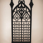 The front of an architectural book nook lantern featuring laser-cut Gothic cathedral window tracery made from 1/8 inch birch plywood painted matte black