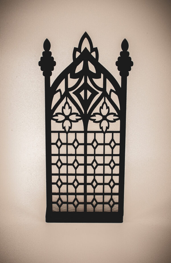 The front of an architectural book nook lantern featuring laser-cut Gothic cathedral window tracery made from 1/8 inch birch plywood painted matte black