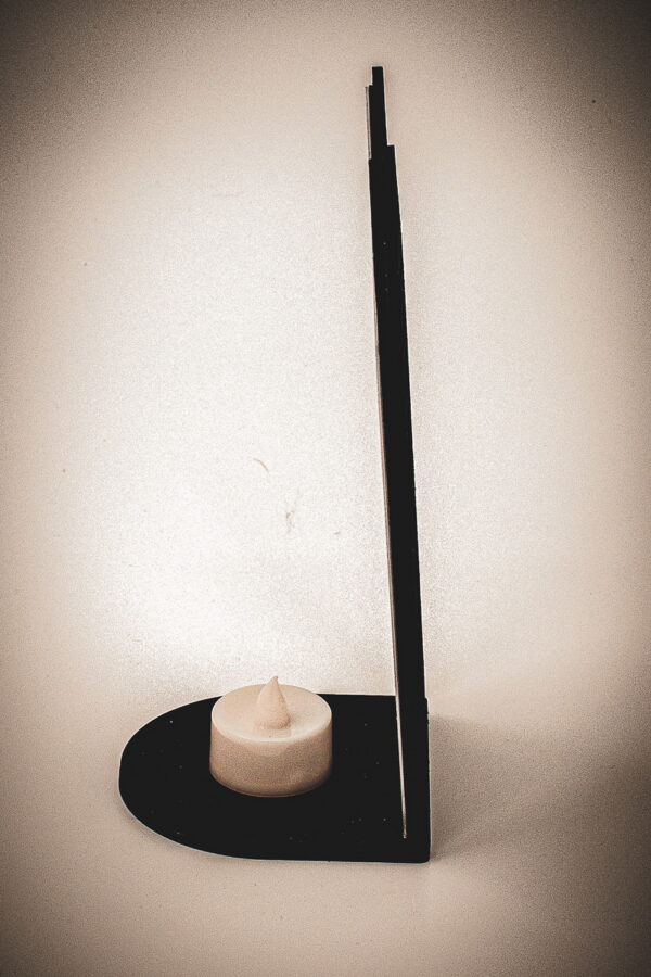 The side of an architectural book nook lantern featuring laser-cut Gothic cathedral window tracery made from 1/8 inch birch plywood painted matte black