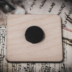 Back of square birch wood magnet featuring Hans Holbein the Younger's Danse Macabre alphabet woodcuts from 1523.