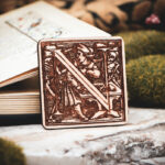 Square birch wood magnet featuring Hans Holbein the Younger's Danse Macabre alphabet letter N woodcut from 1523.