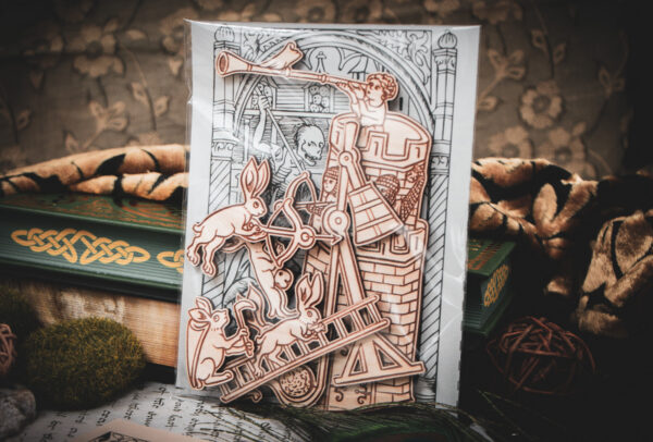 A set of six laser cut and engraved birch magnets featuring rabbits waging battle against knights in a castle tower in a cellophane bag with a gray card of a medieval woodcut print leaning against a stack of books.