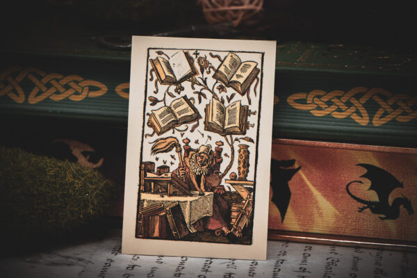 A 16th century German woodcut "4 of Books" playing card leaning against books with decorated edges.
