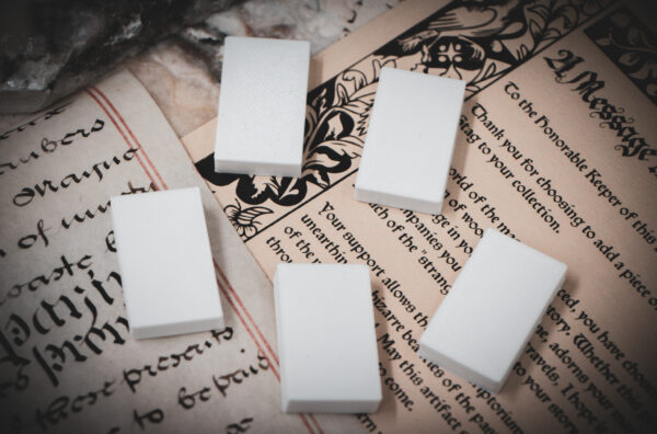 Set of 5 3D printed mini book blanks arranged in a group on top of various papers and a stone surface seen from above