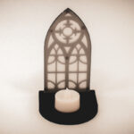 The front of an architectural book nook lantern featuring laser-cut Gothic cathedral window tracery made from 1/8 inch birch plywood painted matte black.