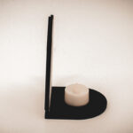 The front of an architectural book nook lantern featuring laser-cut Gothic cathedral window tracery made from 1/8 inch birch plywood painted matte black.