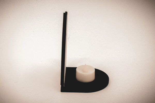 The front of an architectural book nook lantern featuring laser-cut Gothic cathedral window tracery made from 1/8 inch birch plywood painted matte black.